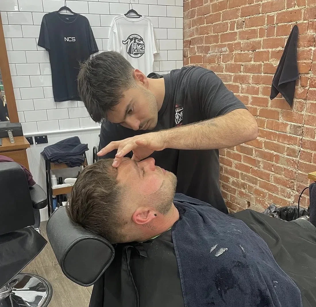 Barber shaping a client's beard